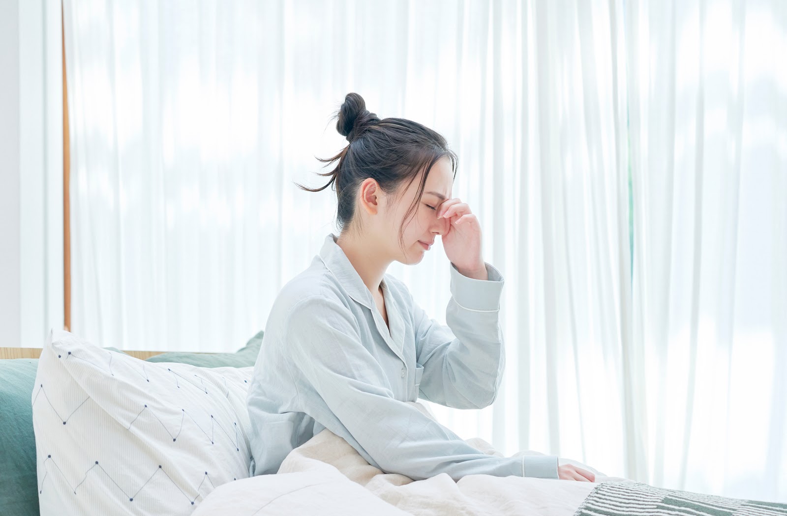 Women in bed touching eyes caused due to dry eye