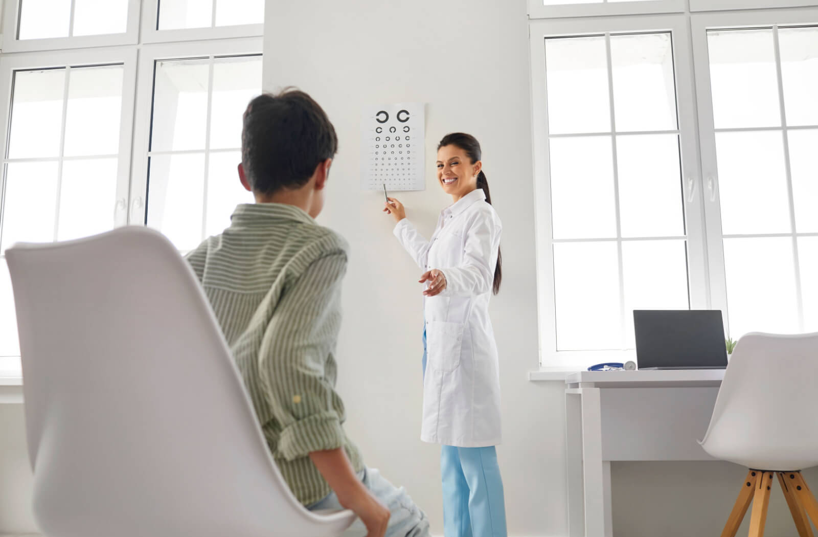 An eye doctor tests a young child's eyesight with the Landolt C eye chart