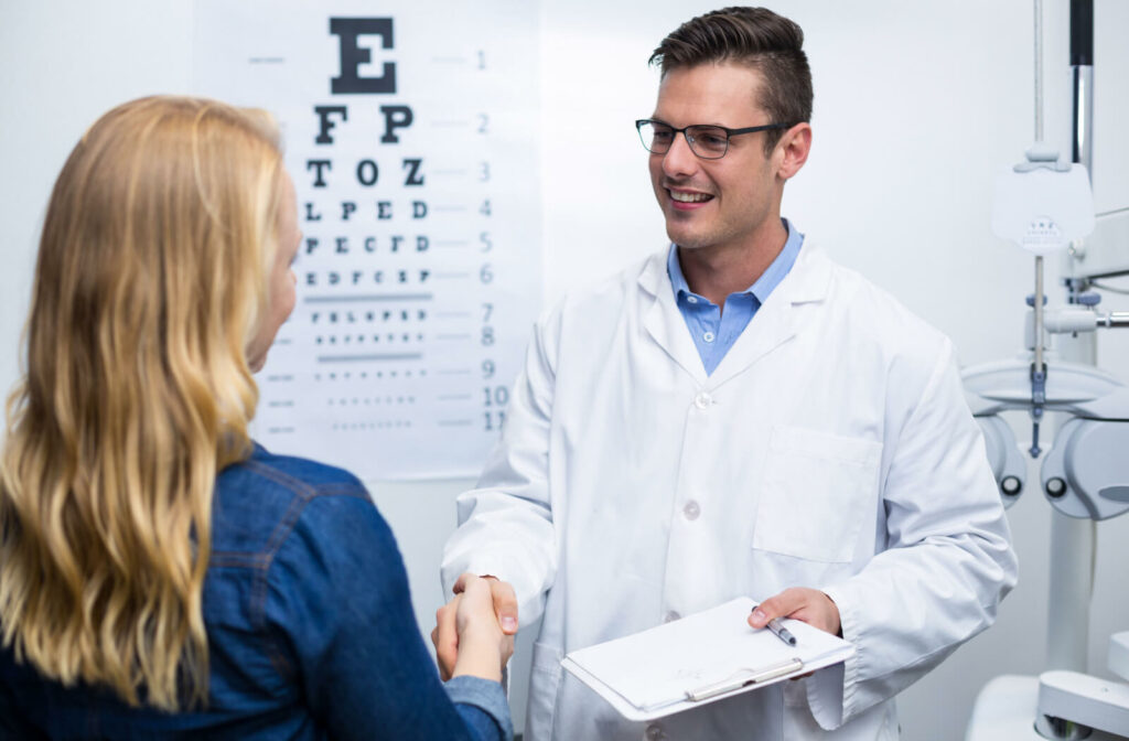 A woman in an optometry clinic shaking hands with a male optometrist