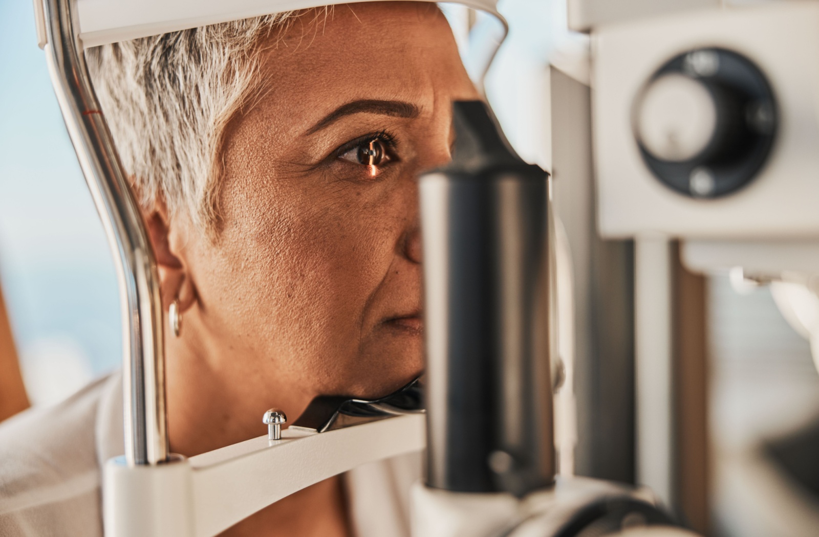 Close-up of an older adult woman undergoing a slit-lamp exam
